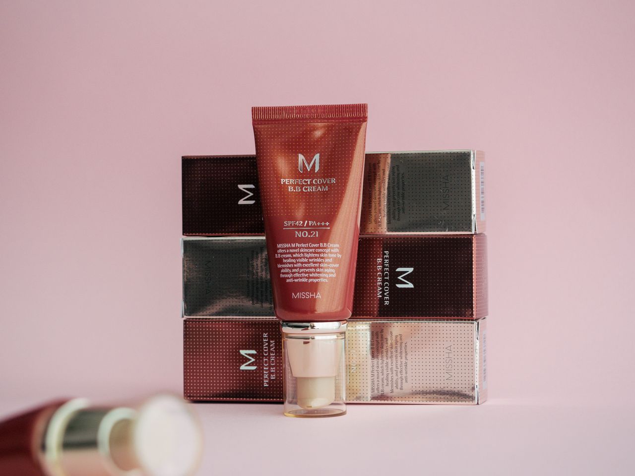 Stylish display of Missha Perfect Cover BB Cream on pink background with packaging.