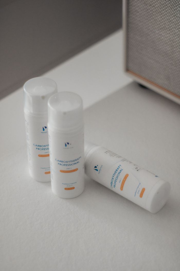 A minimalist image of three skincare product bottles on a white surface, emphasizing cleanliness and simplicity.